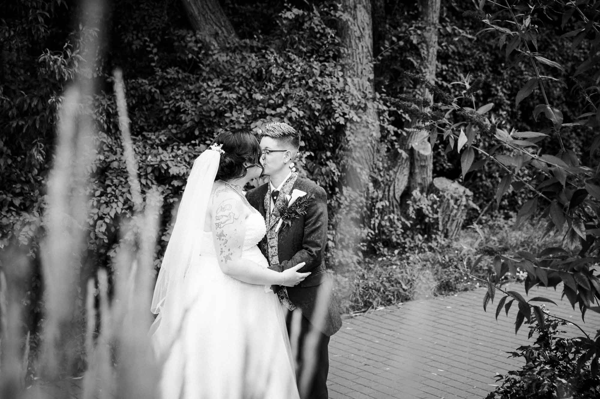 Brautpaar küsst sich, zwei Frauen, gleichgeschlechtliche Hochzeit, schwarz-weiß Aufnahme